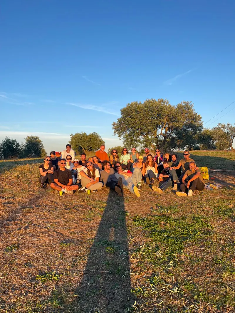 The harvest group sitting together on the hill at sunset